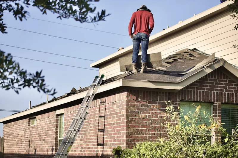 Professional roofer working on a residential roof in Massac